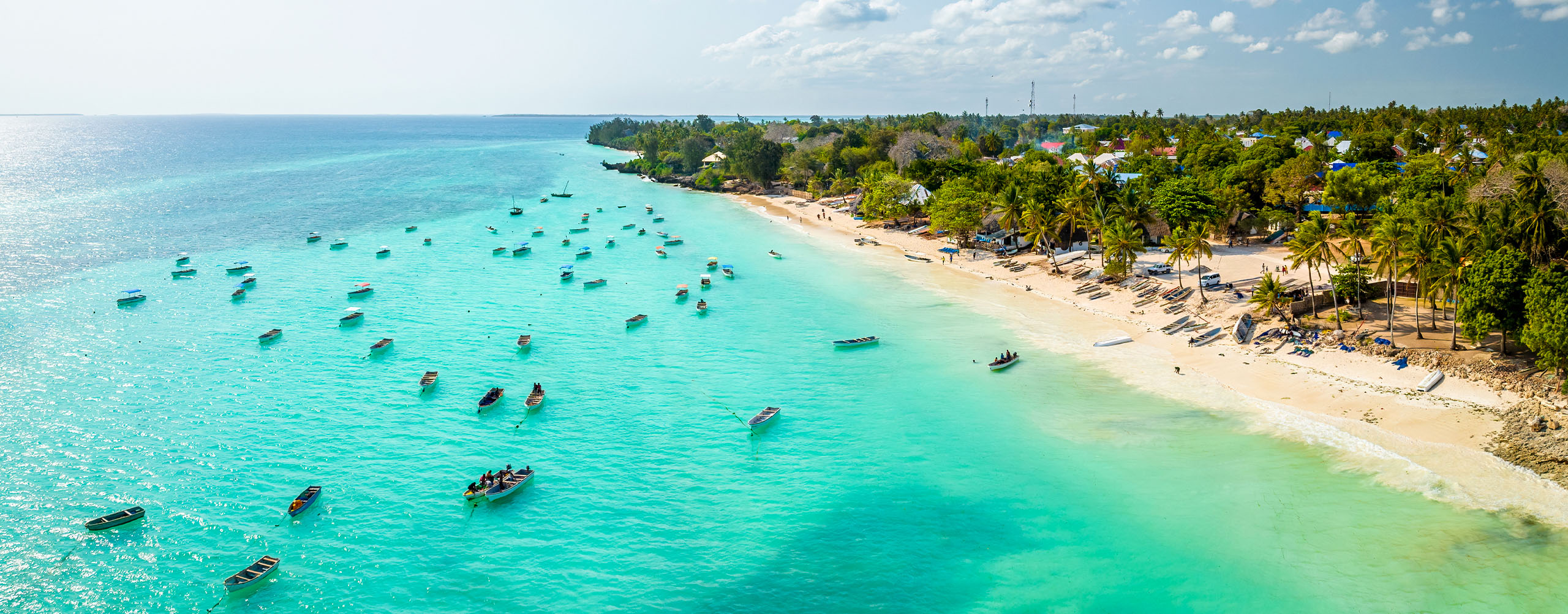 Zanzibar safari beach aerial view — pristine white sand coastline with turquoise Indian Ocean and coral reefs