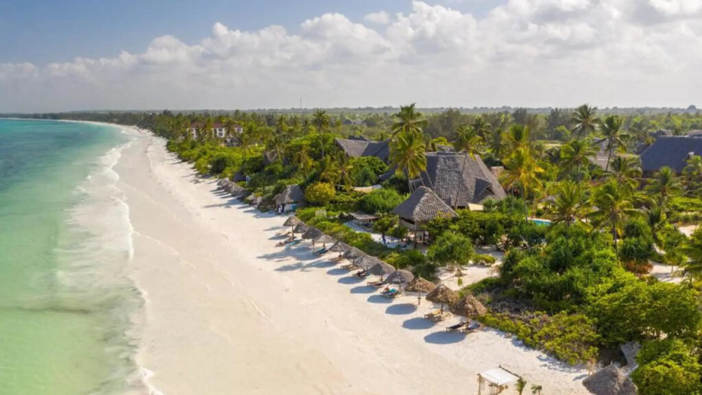 Zanzibar Beach Holidays 1 Pristine white sand Zanzibar beach with turquoise Indian Ocean waters and palm trees, perfect for luxury beach holidays