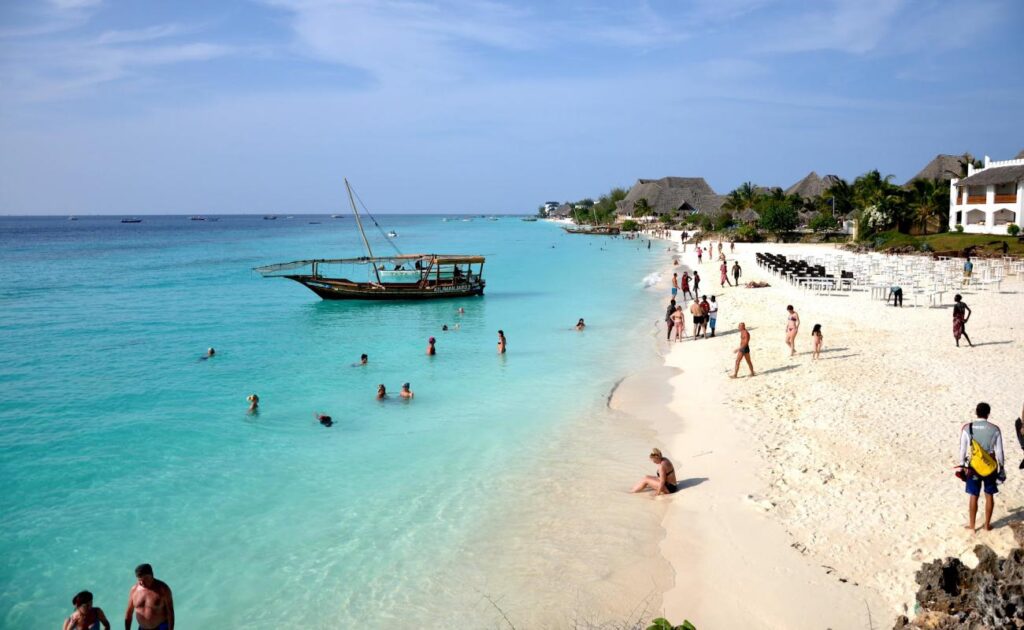 East Coast Low Tide — Dramatic tidal flats with local fishermen and exposed coral formations at Matemwe Beach