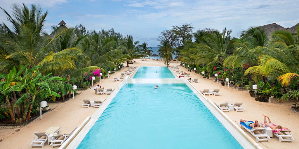 Family Pool Fun — Children playing in dedicated kids pool with waterslide while parents relax at adjacent pool bar at family resort